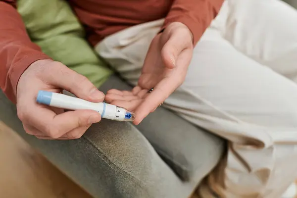 Young man tests his blood sugar at home while following his diabetes care routine. — Stock Photo