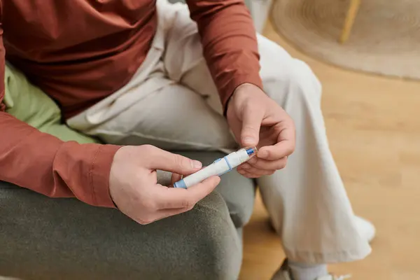 Man checks blood sugar levels at home, integrating diabetes management into daily life. — Stock Photo