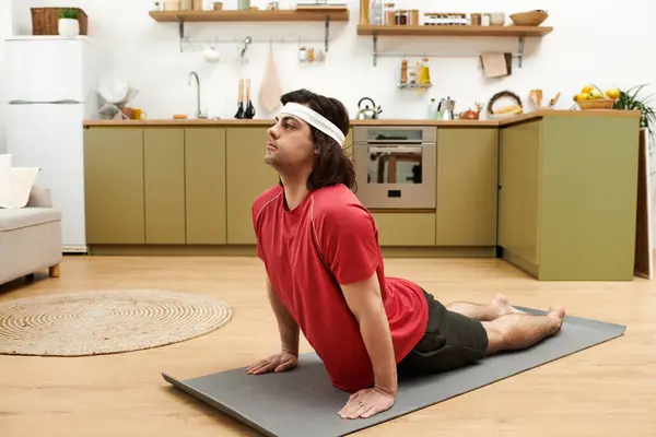 Jovem mostra sua rotina diária de fitness em um tapete em uma cozinha elegante apartamento. — Fotografia de Stock