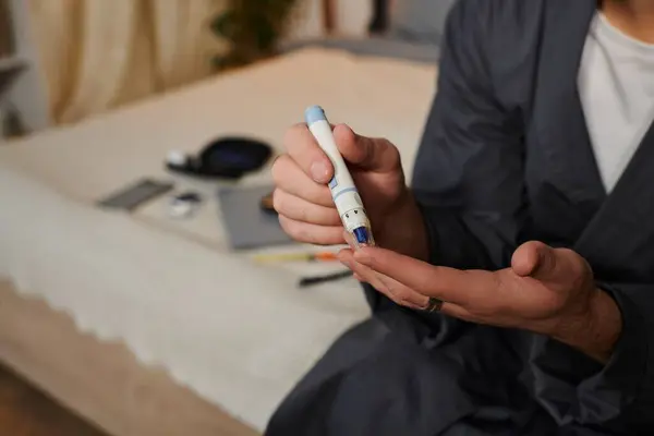 Young Caucasian man checks his blood sugar at home, showcasing his disciplined diabetes care. — Stock Photo