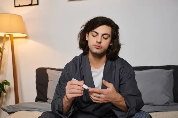Young man with diabetes practices self-care in a modern apartment, showcasing his routine. — Stock Photo