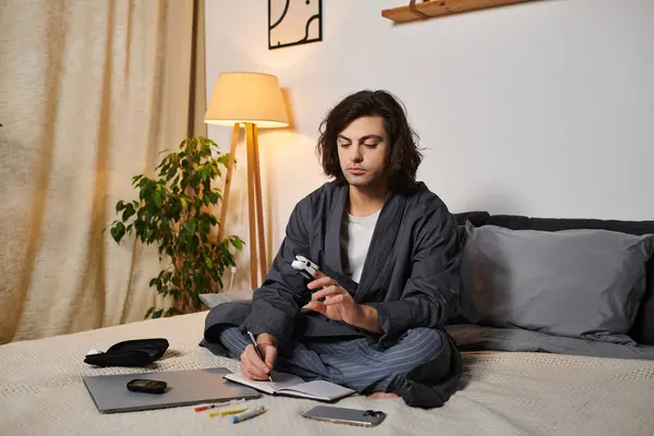 Un giovane uomo in un accogliente appartamento controlla diligentemente il suo zucchero nel sangue mentre annota. — Foto stock
