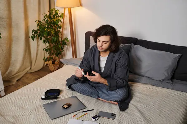 A young man in a cozy apartment checks his blood sugar and prepares insulin with focus and care. — Stock Photo