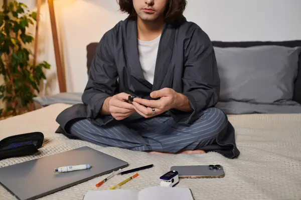 Young man balances his daily routine while managing diabetes in a stylish home environment. — Stock Photo