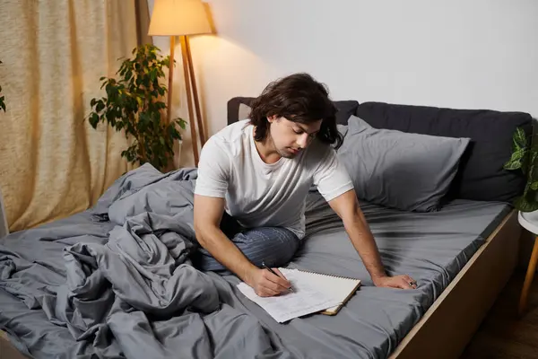 Young man records blood sugar levels while sitting on a bed in his stylish apartment. — Stock Photo