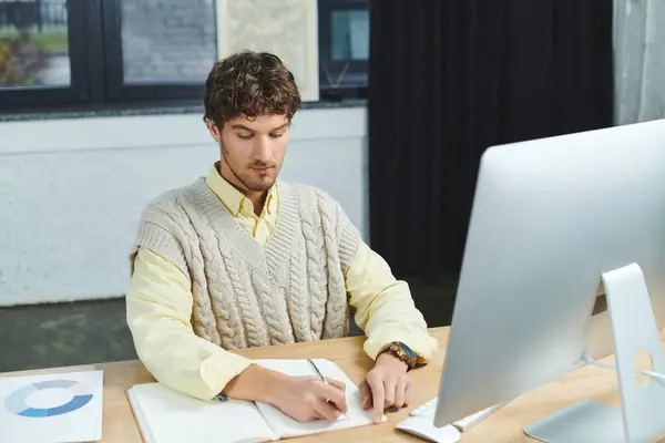 Jeune professionnel en gilet pull se concentre sur son travail, contribuant à un environnement collaboratif. — Photo de stock