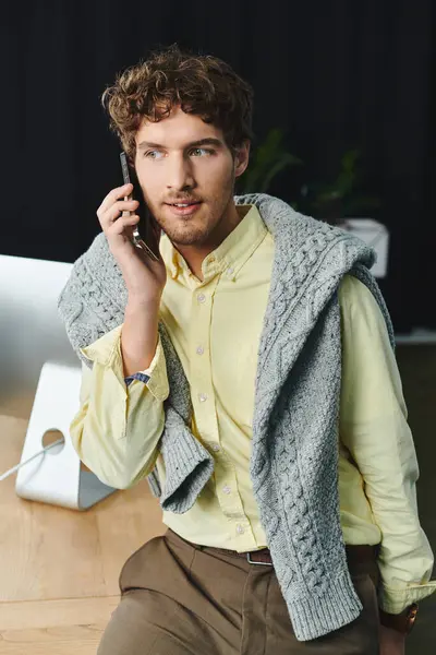 Jeune professionnel engage une conversation téléphonique importante dans un cadre de bureau élégant. — Photo de stock