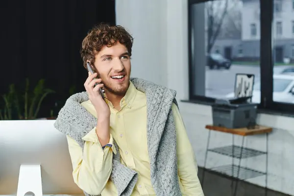 Young man in smart casual attire discusses ideas over the phone in a modern workspace. — Stock Photo