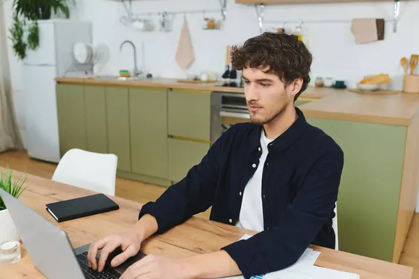 Engaged in work at home, the young man focuses on his laptop in a trendy apartment. — Stock Photo