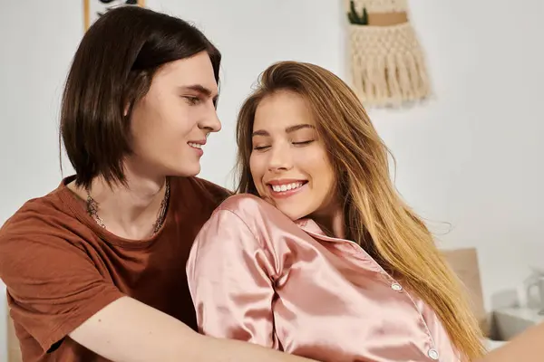 Young couple shares a joyful moment, embracing each other in a trendy and inviting setting. — Stock Photo