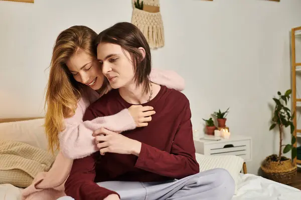 A young couple shares a cozy moment in their stylish, plant filled bedroom. — Stock Photo