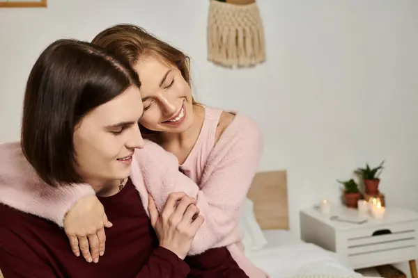 La pareja cariñosa comparte un tierno abrazo mientras está rodeada por un ambiente cálido y acogedor en casa.. - foto de stock