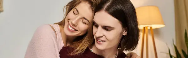 Two young people embrace each other happily, enjoying laughter and warmth indoors together. — Stock Photo