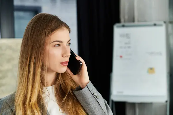 Young chic woman talks on her smartphone in a stylish office during work hours. — Stock Photo