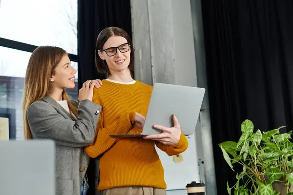 Two young individuals share ideas and smiles while working together in a stylish office environment. — Stock Photo