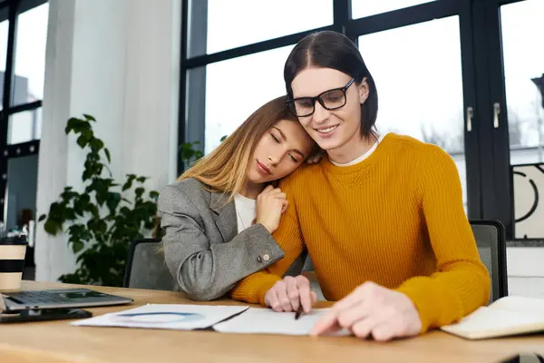 Deux jeunes gens bénéficient d'une connexion chaleureuse alors qu'ils se concentrent sur leurs tâches dans un bureau élégant. — Photo de stock