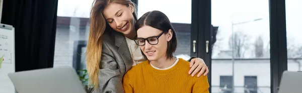 Zwei junge Leute arbeiten begeistert an einem eleganten Schreibtisch zusammen, teilen Ideen und lächeln. — Stockfoto