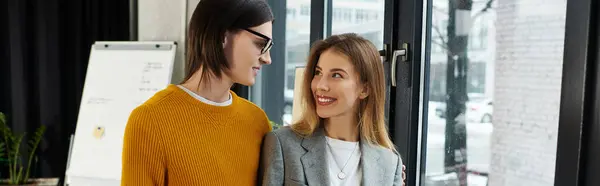 Stylish pair enjoying each others company while admiring the city view through large windows. — Stock Photo