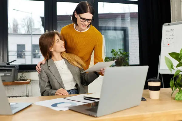 Two young professionals exchange ideas while working together at a stylish office desk. — Stock Photo