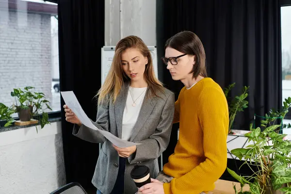 Young individuals engage in a focused discussion while reviewing documents in a stylish workspace. — Stock Photo