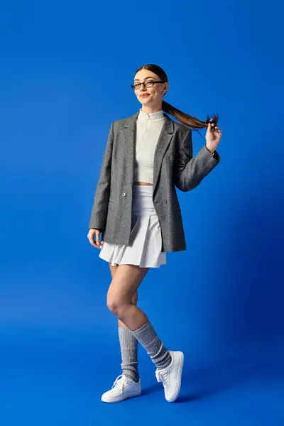 A young woman in a chic outfit playfully poses while showcasing her unique fashion sense. — Stock Photo