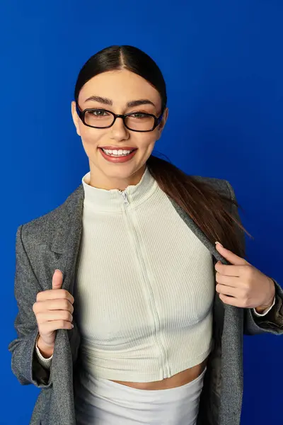 Confident young woman showcases her stylish outfit and radiant smile while posing with excitement. — Stock Photo