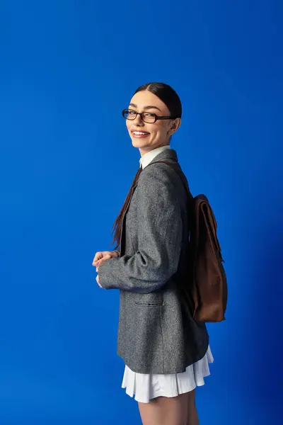 Young woman with glasses exudes joy and confidence as she poses with her backpack. — Stock Photo