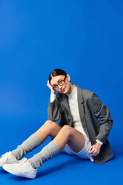 Eine junge Frau zeigt ihre Emotionen vor leuchtend blauem Hintergrund und strahlt Verspieltheit aus. — Stockfoto