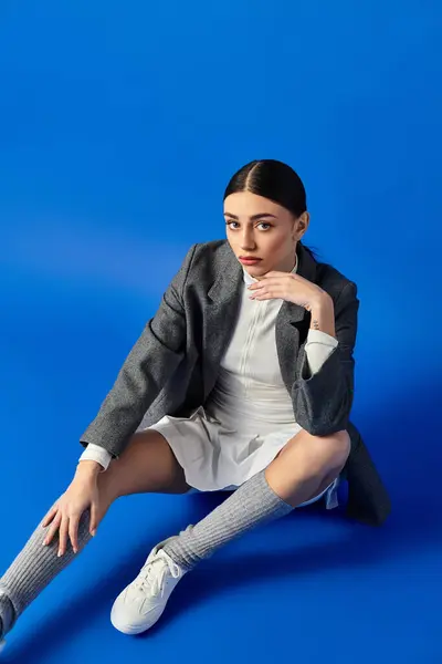 A young beautiful woman showcases her emotions while posing elegantly in a trendy outfit. — Stock Photo