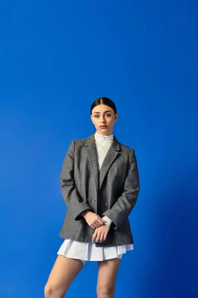 A young woman stands confidently, displaying her emotional depth in a chic outfit. — Stock Photo
