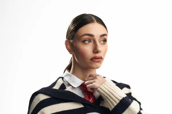A young woman in a striped sweater conveys deep emotions with striking features. — Stock Photo