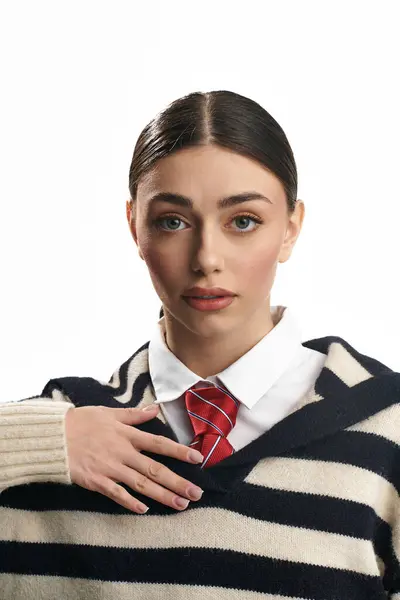 Mujer joven con rasgos llamativos muestra una expresión contemplativa, vestida con elegancia casual. - foto de stock