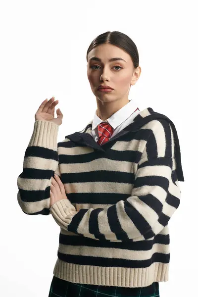 Confident young woman displays her style in a trendy striped sweater. — Stock Photo