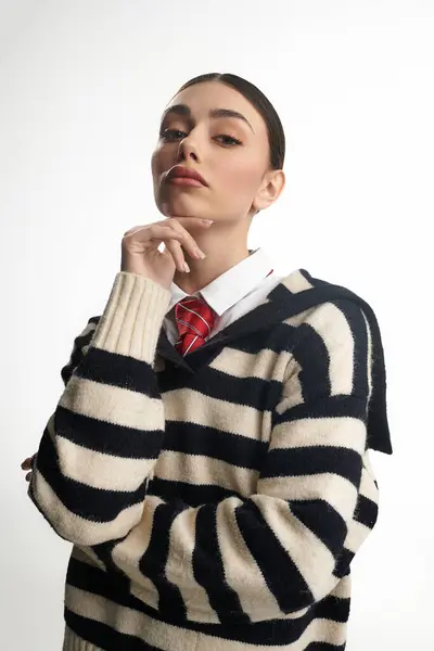 A young woman in a striped sweater showcases emotional depth while posing confidently indoors. — Stock Photo