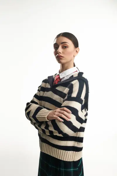 A young woman with an emotional expression stands confidently, showcasing her stylish outfit. — Stock Photo