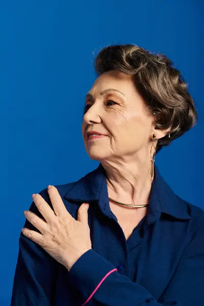 A beautiful woman in her 60s showcases stylish attire, embodying grace and confidence. — Stock Photo