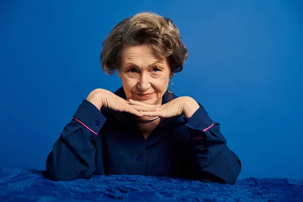 Mature woman showcases her fashion sense while exuding confidence in a studio setting. — Stock Photo