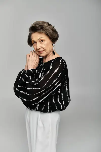 A beautiful woman in her 60s elegantly poses in sophisticated attire, exuding timeless fashion. — Stock Photo