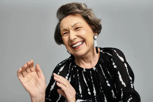 A sophisticated woman in her 60s exudes happiness while dressed elegantly, celebrating her style. — Stock Photo