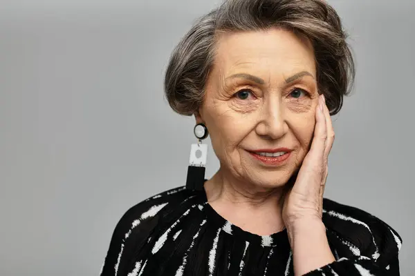 A beautiful woman in her 60s poses gracefully, highlighting her sophisticated fashion sense. — Stock Photo