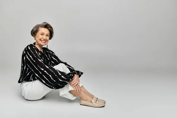 Donna matura in abbigliamento elegante trasuda grazia e fiducia mentre posa con grazia. — Foto stock