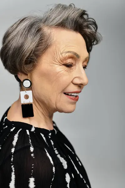 Una bella donna nei suoi anni '60 posa elegantemente, vestita in abiti eleganti con un'acconciatura chic. — Foto stock