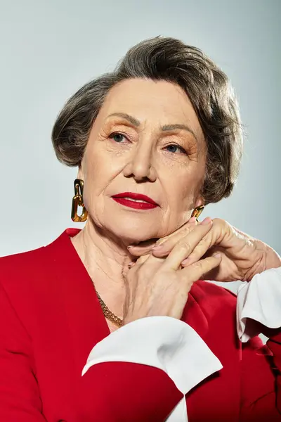 A beautiful woman in her 60s poses gracefully in elegant attire, radiating confidence and style. — Stock Photo