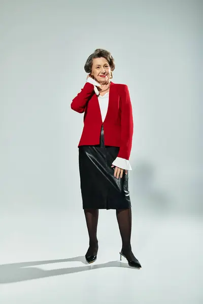 A beautiful woman in her 60s stands elegantly in fashionable attire, showcasing her timeless style. — Stock Photo
