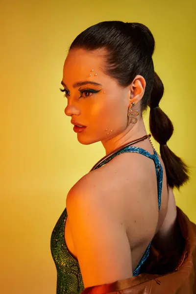 A young woman showcases stunning makeup and fashionable snake print attire, exuding confidence. — Stock Photo