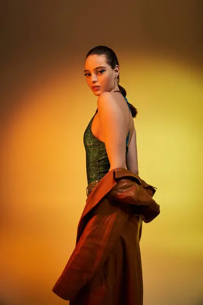 Beautiful young woman exudes confidence in stylish snake print attire within a studio atmosphere. — Stock Photo