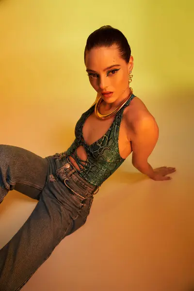 A fashionable young woman showcases stunning makeup and snake print attire in a studio setting. — Stock Photo