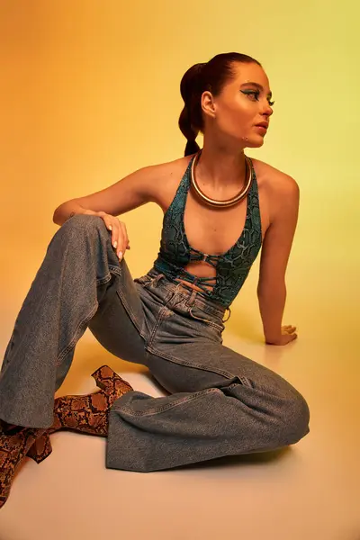 A young woman poses in a stylish snake print outfit, showcasing her gorgeous makeup. — Stock Photo