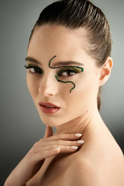 A talented model showcases captivating snake makeup in a well-lit studio setting. — Stock Photo