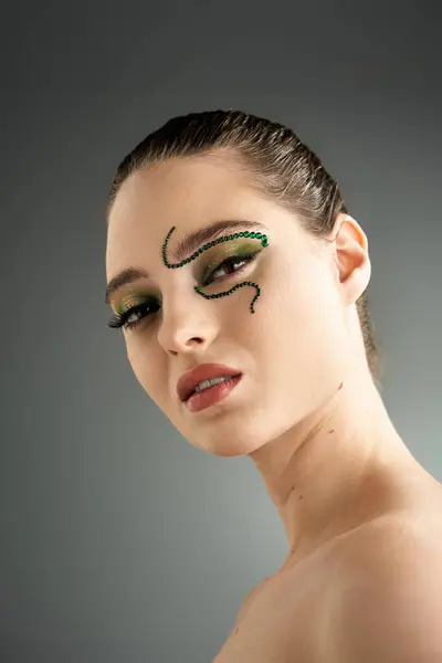 Eine bezaubernde junge Frau präsentiert künstlerisches SchlangenMake-up in einem eleganten Studio-Setting. — Stockfoto